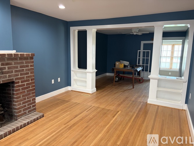 A room with blue walls and a brick fireplace.