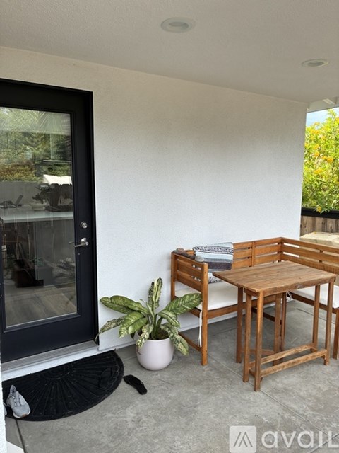A patio with a table and chairs and a potted plant.