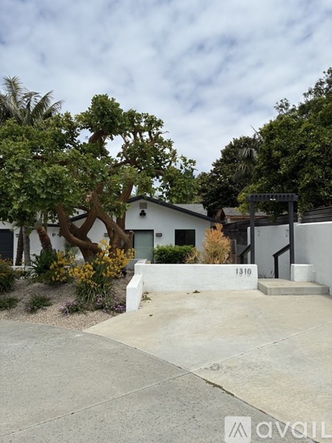 A white house with a tree in front of it.