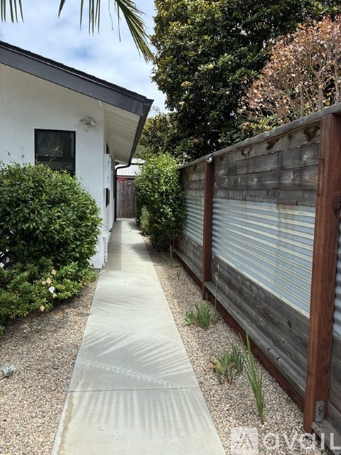 A white house with a grey concrete walkway.