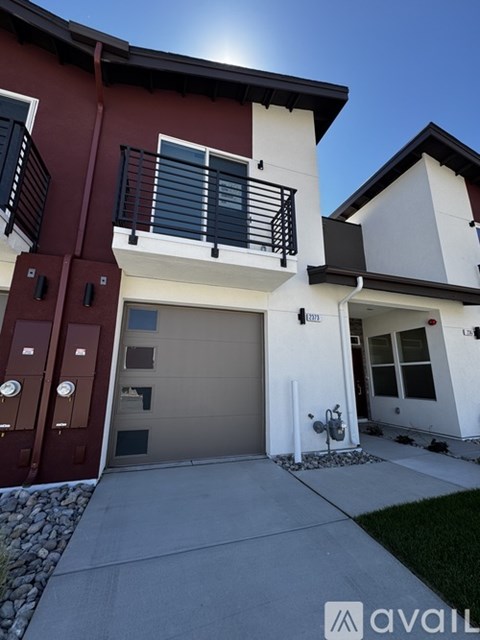 A two-story house with a red and white exterior and a garage door.