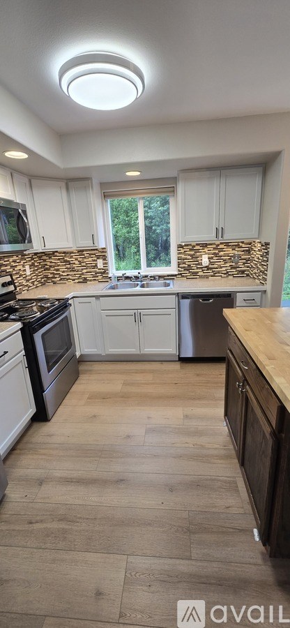 A kitchen with white cabinets and a wooden countertop.
