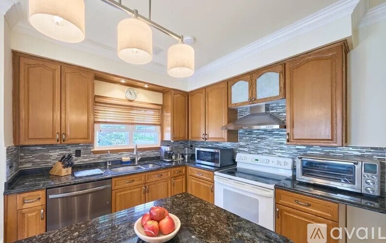 A kitchen with wooden cabinets and granite countertops.