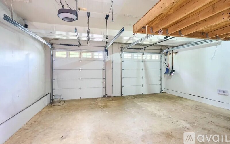 A spacious garage with a white wall and a wooden ceiling.