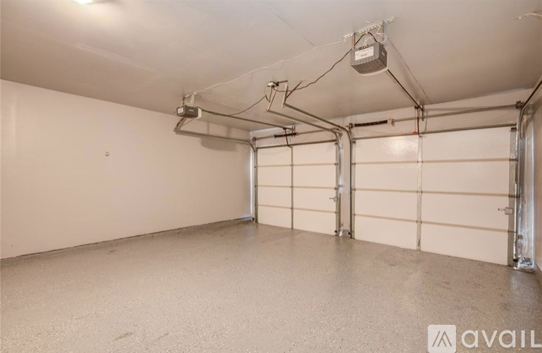A spacious garage with a concrete floor and white walls, equipped with a ventilation system.