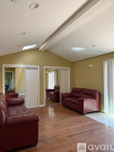 A living room with a red couch and two chairs.