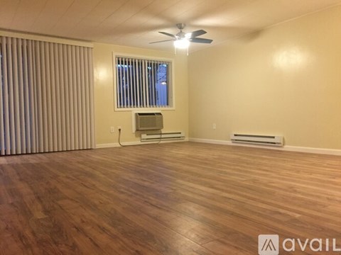 A room with wooden flooring and a ceiling fan.