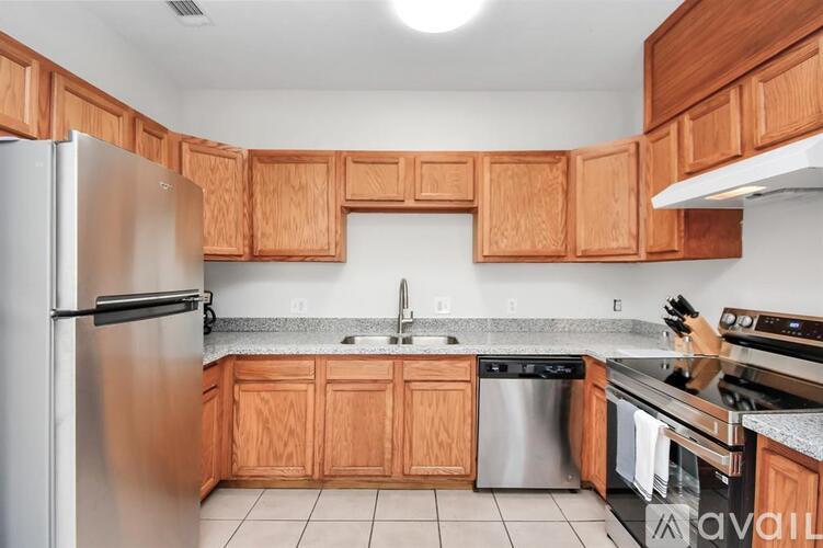 A kitchen with wooden cabinets and a stainless steel refrigerator.