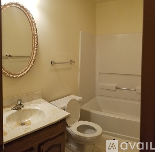 A bathroom with a toilet, sink, and mirror.