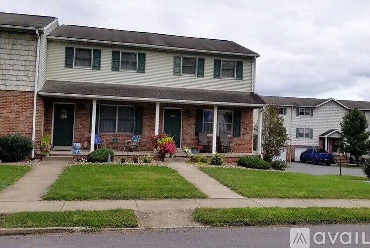 A house with a front yard and a car parked in the driveway.