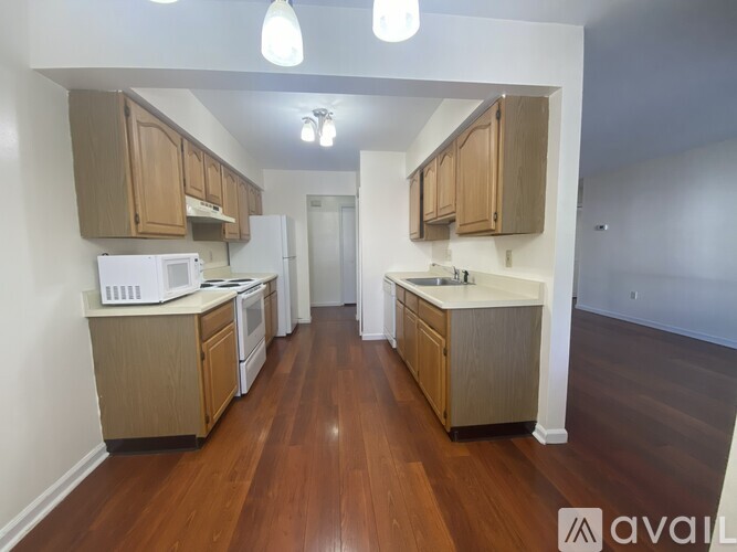 A kitchen with wooden cabinets and a white fridge.