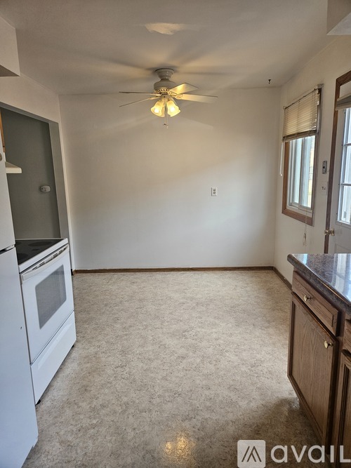 A kitchen with a fan on the ceiling and a stove top oven.