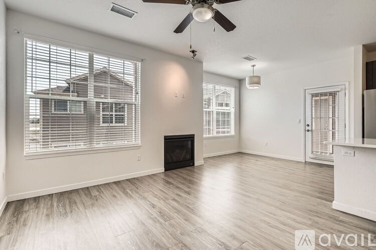 A spacious living room with a ceiling fan and a fireplace.