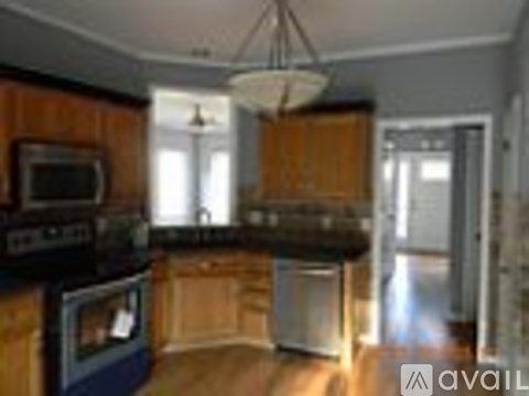 A kitchen with wooden cabinets and a black stove top oven.