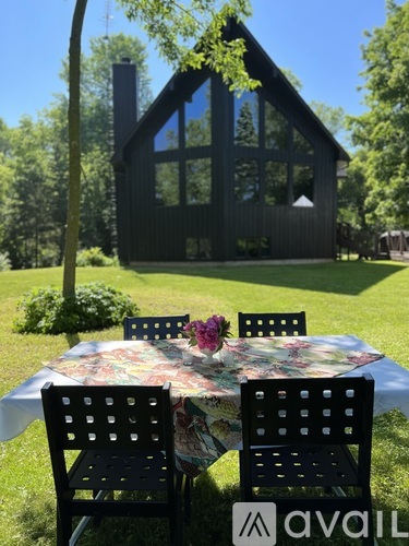 A table with chairs is set up outside in front of a house.