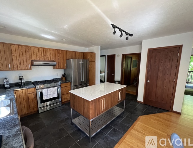 A kitchen with wooden cabinets and a stainless steel refrigerator.