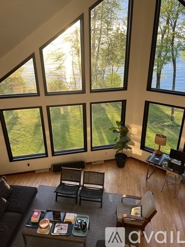 A living room with a couch, chair, and coffee table with a view of the outdoors.