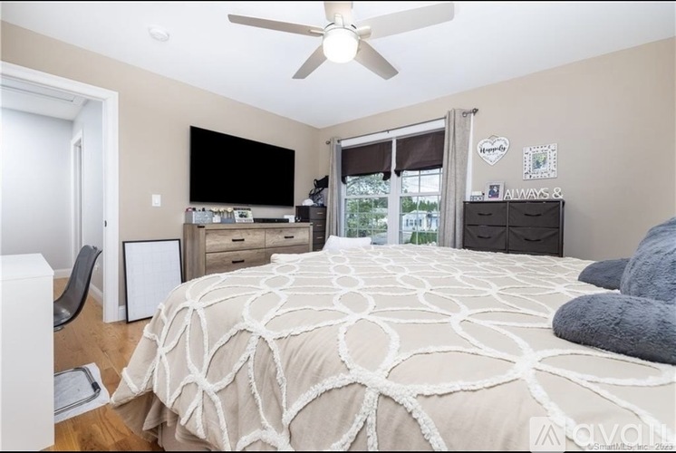 A bedroom with a large bed and a flat screen TV.