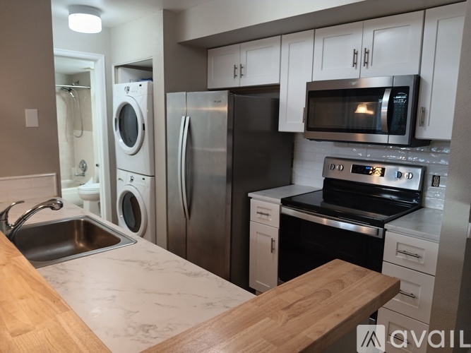 A kitchen with a sink, refrigerator, oven, and microwave.