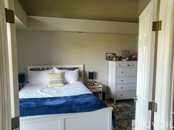 A bedroom with a bed, nightstand, and dresser.
