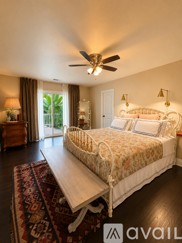 A bedroom with a large bed and a rug in front of it.