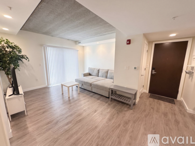 A living room with a white sofa and a wooden floor.