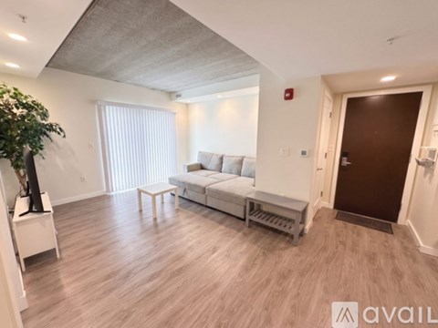 A living room with a white sofa and a wooden floor.