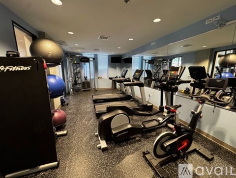 A gym with treadmills, exercise bikes, and a weight machine.