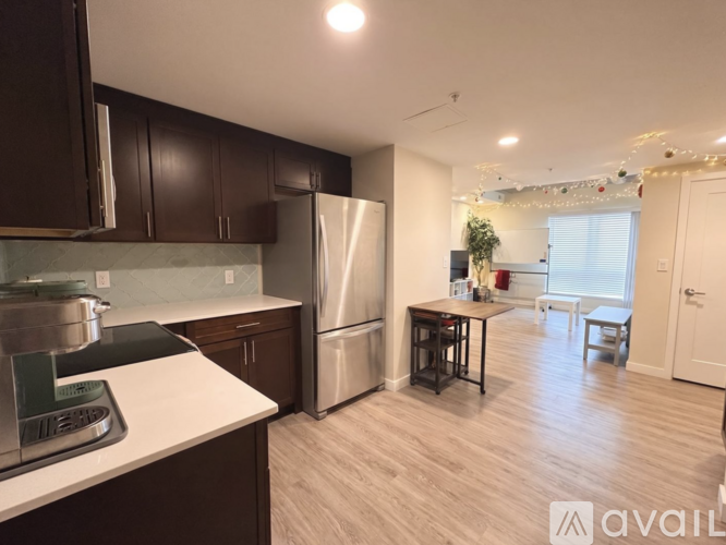 A kitchen with dark brown cabinets and a stainless steel refrigerator.