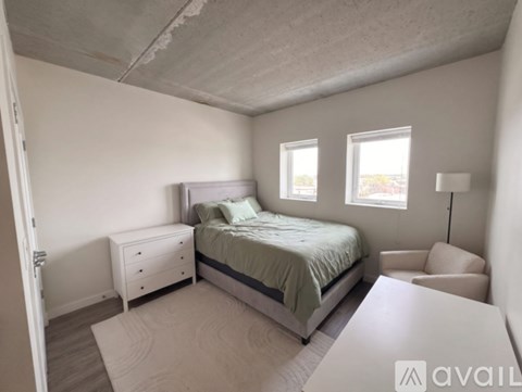 A bedroom with a bed, nightstand, and chair.