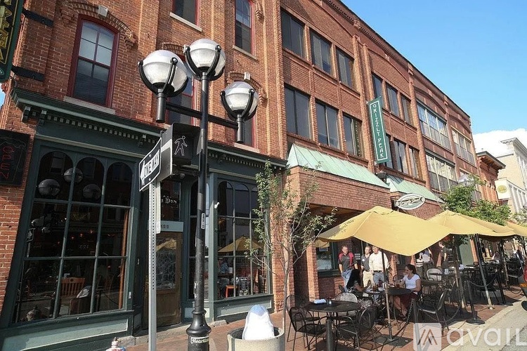 A street view of a building with a green awning and a yellow umbrella.