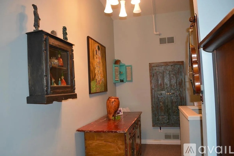 A room with a wooden cabinet and a painting on the wall.