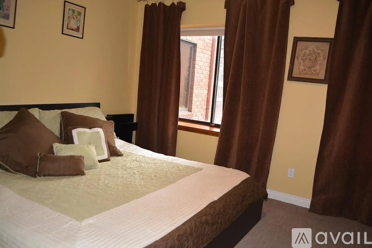 A bedroom with a large bed and brown curtains.