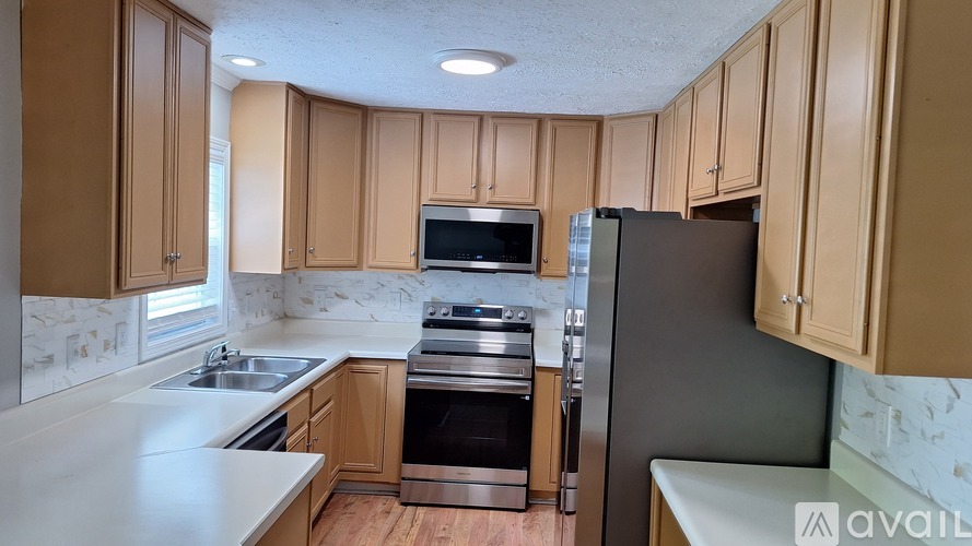 A kitchen with wooden cabinets and a stainless steel refrigerator.