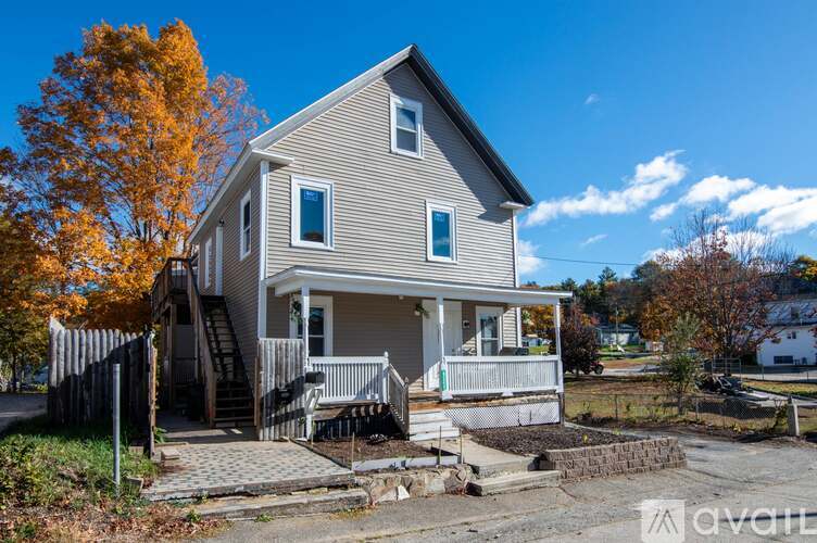 A house with a grey exterior and a white porch is for sale.