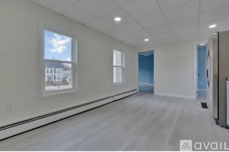 A spacious room with a view of the city through a window.