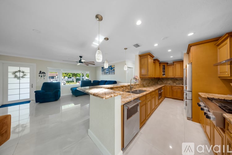 A modern kitchen with wooden cabinets and a marble island.
