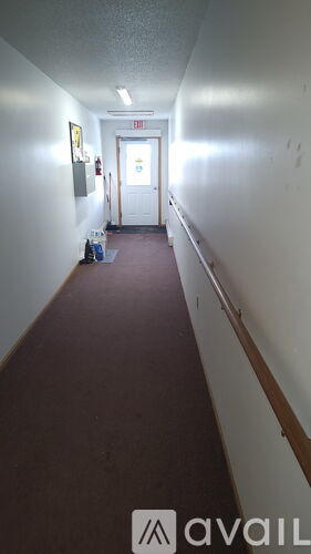 A long hallway with a red carpet and white walls.