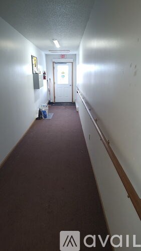 A long hallway with a red carpet and white walls.