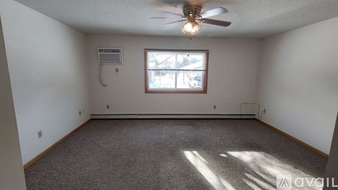 A room with a ceiling fan and a window.