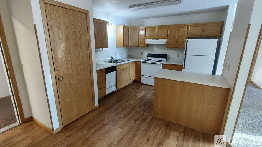 A kitchen with wooden cabinets and a white fridge.