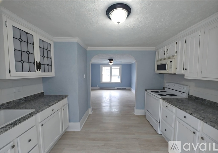 A kitchen with white cabinets and a granite countertop.