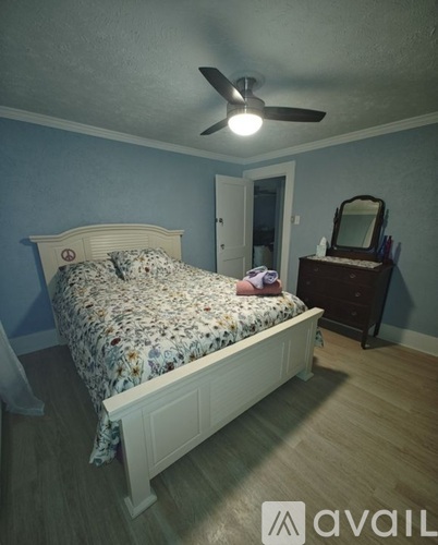 A bedroom with a bed, dresser, and mirror.