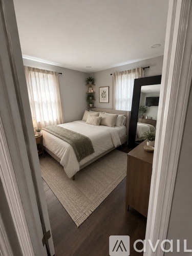 A bedroom with a bed, a mirror, and a rug.