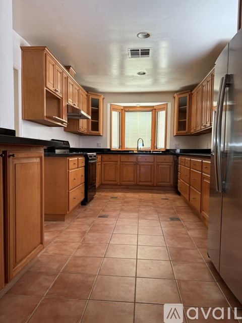 A kitchen with wooden cabinets and tile flooring.