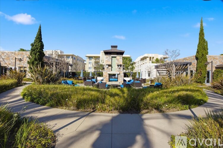A sunny day at a park with a building in the background and a sign that says "avail".