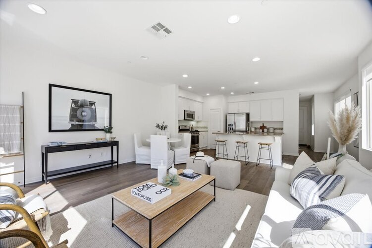 A modern living room with a white sofa and a wooden coffee table.