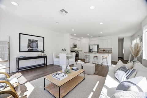 A modern living room with a white sofa and a wooden coffee table.