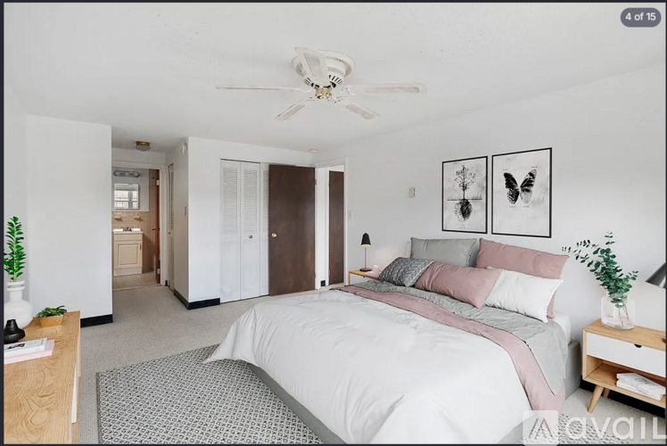 A bedroom with a large bed and a ceiling fan.