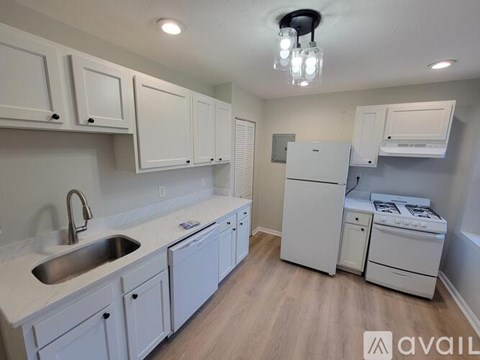 A kitchen with white cabinets and appliances.